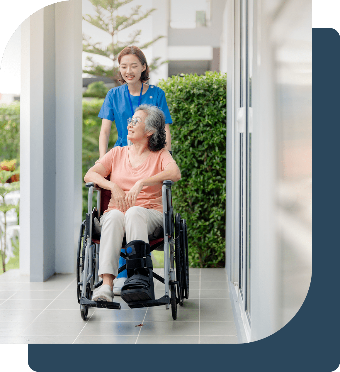 Caregiver assisting elderly woman in wheelchair